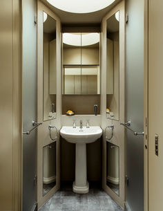 a bathroom with a pedestal sink and mirrors