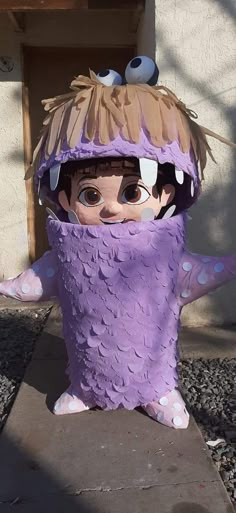 a statue of a person wearing a purple outfit with eyes on it's head