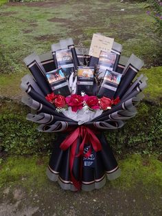 a bouquet of flowers is sitting on the ground in front of some grass and bushes