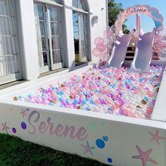 an inflatable pool is decorated with balloons and confetti