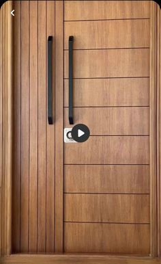 a close up of a wooden door with black handles