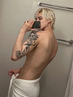 a man taking a selfie in the bathroom while wearing a towel and holding a cell phone up to his face