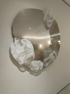 a circular mirror hanging on the side of a wall with ice cubes in it