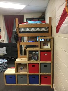 a bunk bed with red, white and blue bins on it's bottom shelf