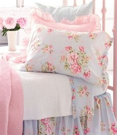 a bed with pink and blue comforters on top of it