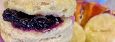 a person holding up a pastry with blueberries on it