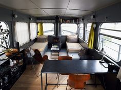 the inside of a bus with tables and chairs