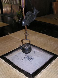 a tea pot on a tray with a hook attached to it