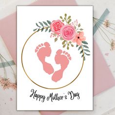 a mother's day card with pink flowers and baby feet in a gold circle