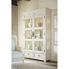 a white china cabinet with glass doors in a living room