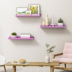 two chairs and a coffee table in front of a white wall with three shelves on it