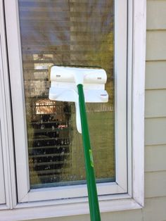 a green mop sitting on top of a window sill