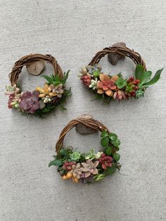 three wreaths with succulents and rocks on the ground