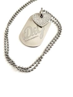 VINTAGE DOLCE GABBANA NECKLACE  Silver metal base with big panel signes D&C and Dolce Gabbana ,top on panel Rhinestone heart This necklace is beautiful cond and its priced to sell  ca 1980s D&G. Chain 22 inc long  Panel 1,5 inc long 1,1 inc wide. Year 2, Rhinestone Heart, Dog Tag, Locket Necklace, Dolce & Gabbana, Metal Base, Necklace Silver, Vintage Tops, Vintage Earrings