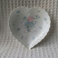 a heart shaped dish with flowers on it