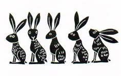 three black rabbits sitting next to each other