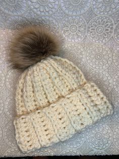 This cozy winter hat is made from chunky acrylic yarn and a faux fur Pom Pom. It's the perfect gift for your girlfriend, mom, self, or even your mom! Winter Crochet Cream Hat, Warm Crochet Yarn Hat For Gift, Warm Crochet Yarn Hat As Gift, Warm Yarn Crochet Hat As A Gift, Yarn Crochet Hat For Gift, Winter White Crochet Hat As Gift, White Crochet Hat For Winter Gift, Handmade Cream Crochet Hat For Winter, Winter Crochet Yarn Hat Gift