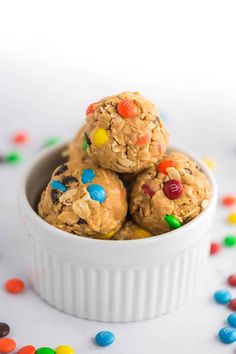 three cookies in a white bowl surrounded by candy