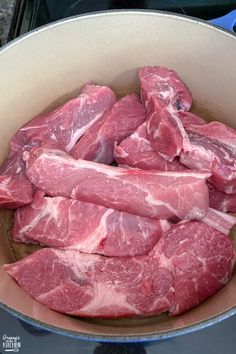 some raw meat in a pot on the stove ready to be put into the oven