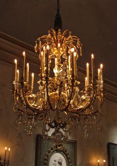 a fancy chandelier hangs in the middle of a room with candles on it