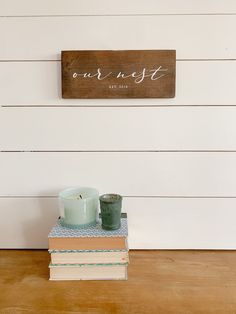 two candles are sitting on top of books in front of a sign that says our guest