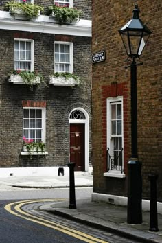 an old brick building with flower boxes on the windows and street lights in front of it