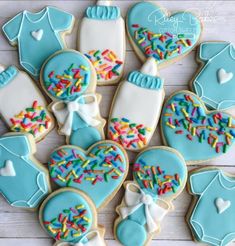 cookies decorated with blue icing and sprinkles are arranged on a table