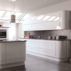 a modern kitchen with white cabinets and stainless steel appliances