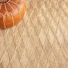 a brown ottoman sitting on top of a rug next to a wooden footstool