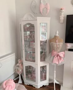 a white display cabinet with pink bows on it