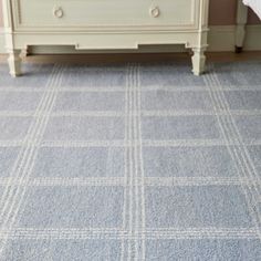 a bedroom with a blue carpet and white dresser