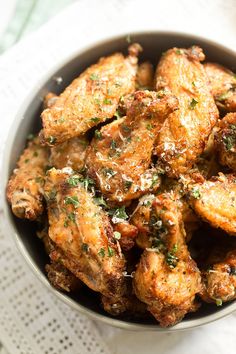 garlic parmesan wings in a bowl on top of a white tablecloth with the words garlic parmesan wings above it