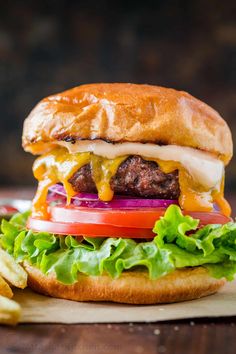 a cheeseburger with lettuce, tomato and onion