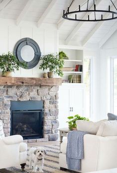 a living room filled with furniture and a fire place in front of a stone fireplace