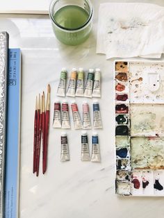 some paint and brushes are sitting on a table