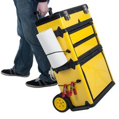 a man is pulling a yellow suitcase with wheels and paper on the handle, while another person stands behind it