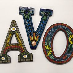 the letters have been made out of stained glass and are painted with different colors, shapes and sizes