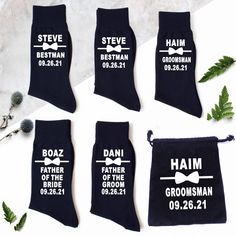 four socks with names and bow ties on them, sitting next to some plants in the background