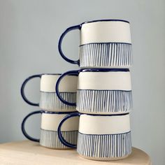 four blue and white cups stacked on top of each other