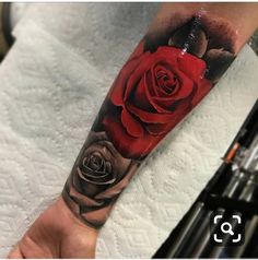 a person with a red rose tattoo on their arm