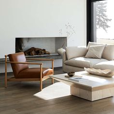 a living room filled with furniture and a fire place in front of a large window