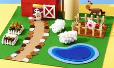 a farm scene made out of paper with animals and sheep on the grass next to a red barn