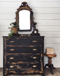 an old dresser with a mirror on top and a plant growing out of it's drawer