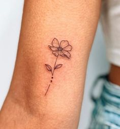 a small flower tattoo on the left inner arm and wrist is shown in black ink