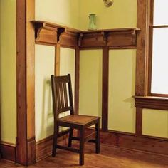 a wooden chair sitting in front of a window next to a shelf with a vase on it