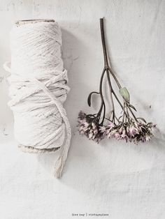 two spools of twine next to some flowers