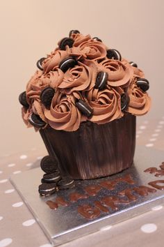 a cupcake decorated with chocolate frosting on top of a table