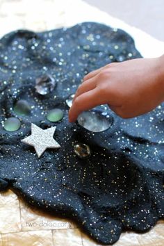 a hand reaching for a star on top of a black piece of paper with buttons