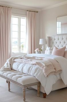 a white bed sitting in a bedroom next to a window with pink drapes on it