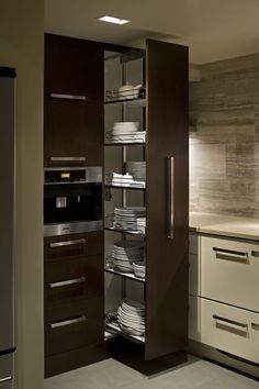 an open cabinet in a kitchen filled with dishes